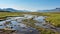 Arctic Wolf Wetland: A Serene River Surrounded By Green Grass