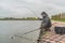 Area trout fishing. Fisherman with spinning rod in action playing fish