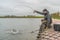 Area trout fishing. Fisherman with spinning rod in action playing fish