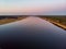 Areal drone view of small river near pine tree forest.