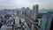 Areal view of busy Tokyo city showing dense highrise buildings, train tracks, and highways with background sky