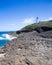 Arecibo lighthouse from Puerto Rico coast with rocky shore and ocean