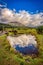 Arenal Volcano in Costa Rica\\\'s Arenal National Park, is seen from a field and reflected in a lake.