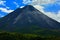 Arenal Volcano in Costa Rica. Volcano with exhalation and ash. Beautiful tropic landscape with volcano. Cone active volcano in