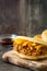 Arepa with shredded beef and cheese on wood. Venezuelan typical food
