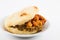 Arepas filled with shredded beef and pork rind served in white dish