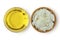 Argan oil in glass bowl and karitÃ© shea butter in wooden bowl on white background