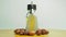 Argan oil in a oriental glass and metal bottle and argan nuts motion on wooden table and white background.