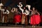 Argentinian dancers waving white cloth at night stage