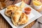 Argentinian homemade empanadas on square white plate, red sauce and lemon slices on wooden table