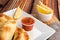 Argentinian homemade empanadas on square white plate, red sauce and lemon slices on wooden table