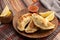 Argentinian homemade empanadas on wooden plate with red sauce and lemon slices