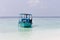 Ari Atoll, Maldives: A maldivian sailor is fishing on his blue boat called `dhoni`