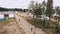 Arial shot road at sand beach people play volleyball and gorodki. Mascot walking