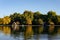 Arial view of lake surrounded by dense autumn trees and wooden buildings at Hyde park