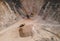 Arial view of the open pit mine. Front end loader loading gravel into stone jaw crusher in open-pit. Limestone quarry development