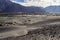 Arid dry dessert sand dunes of nubra valley with himalayan barren mountain range in the background at ladakh, Kashmir, india