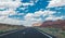 Arid landscape of Arizona. The crumbling sandstone mountains and the highway