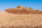 Arid landscape with barren land and parched earth with ruins of farmhouse