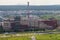 Ariel panoramic view of city and skyscrapers with a huge factory with smoking chimneys in the background