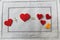 Arithmetic of love. Example with hearts on a white napkin with embroidery