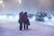 Arkhangelsk, Russia - january 22, 2017: Man and woman cross road at heavy night winter snowstorm. Low visibility, street