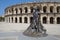 Arles, France - July 15, 2013: Roman Arena (Amphitheater) in Arles and bullfighter sculpture, Provence, France