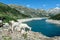 Arlhoehe - A group of goats standing at the shore of an artificial lake in Austria