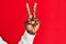 Arm and hand of african american black young man over red isolated background counting number 2 showing two fingers, gesturing