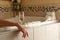 Arm of a Woman Relaxing in the Bathroom Spa Tub with a Glass of Sparkling Champagne and Candles