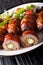 Armadillo eggs are a classic Texas BBQ staple served with salad close up on a plate. vertical