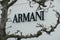 Armani trademark sign, through a tree at Maasmechelen village outlet