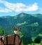 An armchair with a plaid blanket and a bouquet of flowers overlooking the mountain landscape.