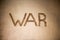 Armchair war. Word war on soft brown blanket. Text