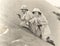 Armed couple climbing up sand dune