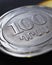 Armenian coins lie on a dark black surface close-up. 100 dram coin. Money of Armenia. News about economy or banking. Loan and