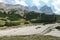 Armentarola - A panoramic view on a valley with a vast dried lake area in Italian Dolomites. Sharp and stony mountain