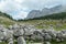 Armentarola - A stony wall made of bigger lose boulders on a lush green meadow in Italian Dolomites