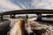 armless man rides wave on wakeboarding board against the background of bridge