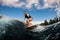 armless man wakesurfing on the board down the wave against the background of sky