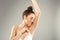 Armpit epilation, lacer hair removal. Young woman holding her arms up and showing clean underarms,