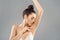 Armpit epilation, lacer hair removal. Young woman holding her arms up and showing clean underarms, depilation  smooth clear skin