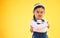 Arms crossed, portrait and angry girl child in studio with bad, attitude or behavior problem on yellow background. Frown