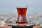 Armudu with Turkish tea stands atop rooftop fence, with defocused view of Istanbul.