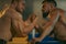 The Armwrestling. Two strong athletes in the gym compete in arm wrestling. Bodybuilders armwreslers in athletic training