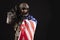 Army of america. A soldier in military equipment with a gun holds the USA flag on a black background, American special forces