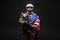 Army of america. A soldier in military equipment with a gun holds the USA flag on a black background, American special forces