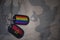 army blank, dog tag with flag of angola and gay rainbow flag on the khaki texture background.