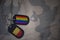 army blank, dog tag with flag of belgium and gay rainbow flag on the khaki texture background.