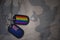 army blank, dog tag with flag of new zealand and gay rainbow flag on the khaki texture background.